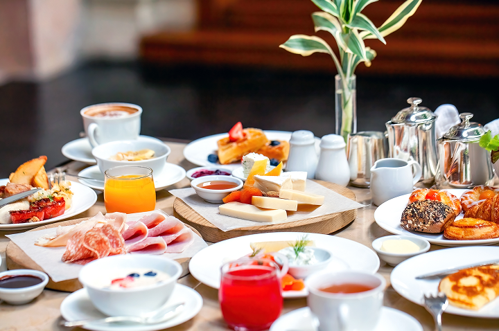 Ein gedeckter Tisch mit frischem Obst, Croissants und Kaffee in einem einladenden Ambiente.