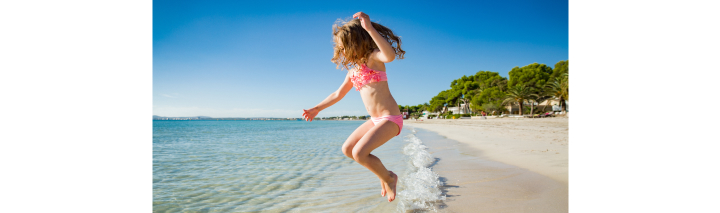 Glückliches Mädchen spielt am Strand.