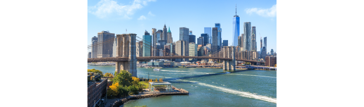 Die Skyline von New York City mit markanten Wolkenkratzern und dem Hudson River im Vordergrund.