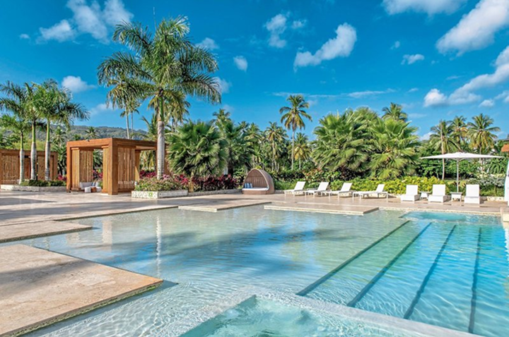 Moderner Außenpool mit Liegestühlen, Sonnenschirm und Palmen im Hintergrund. Moderner Außenpool mit Liegestühlen, Sonnenschirm und Palmen im Hintergrund.