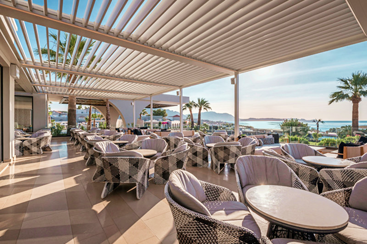 Strandestaurant im Hotel mit Blick auf das Meer, ausgestattet mit einladenden Tischen und Stühlen für Gäste.