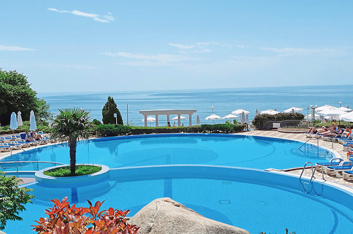 Ein großer Pool umgeben von Liegen und Sonnenschirmen, ideal zum Entspannen an einem sonnigen Tag.